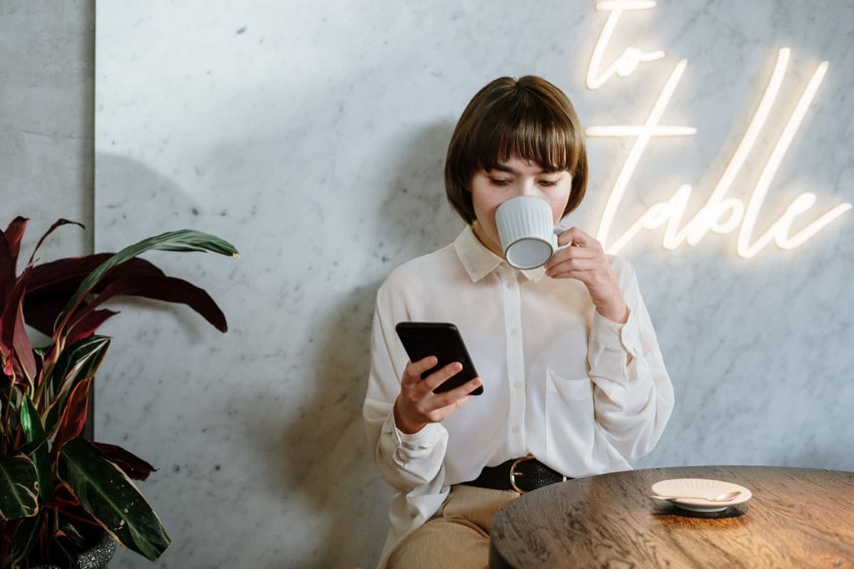 A woman searching on her phone in a café