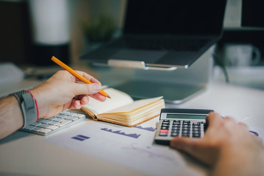 Person at a desk with a calculator and notebook