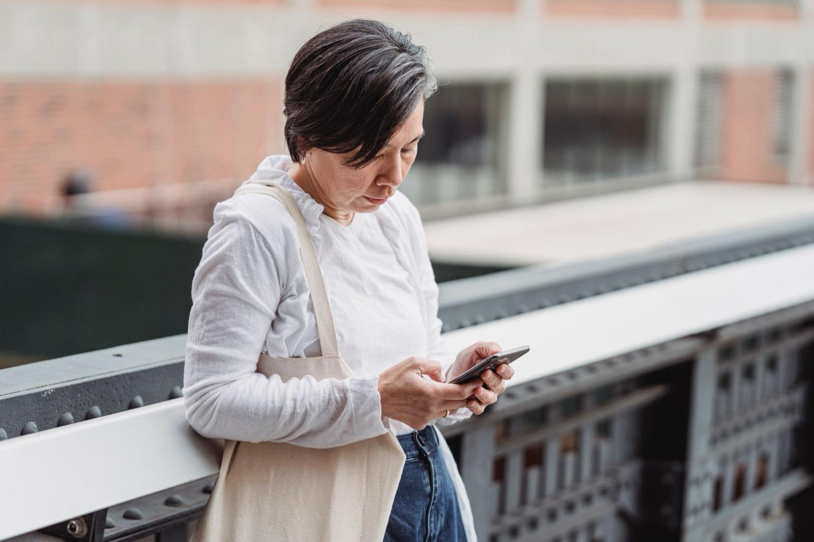 A woman scrolling on her phone outdoors