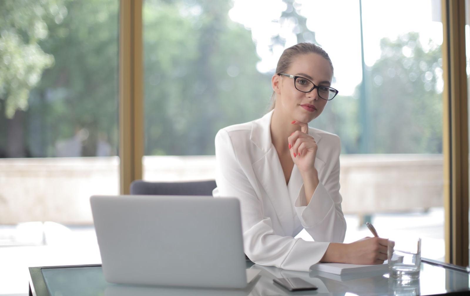 A sales manager at her laptop by the window